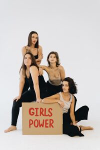 Group of women posing with a Girls Power sign, symbolizing empowerment and unity.